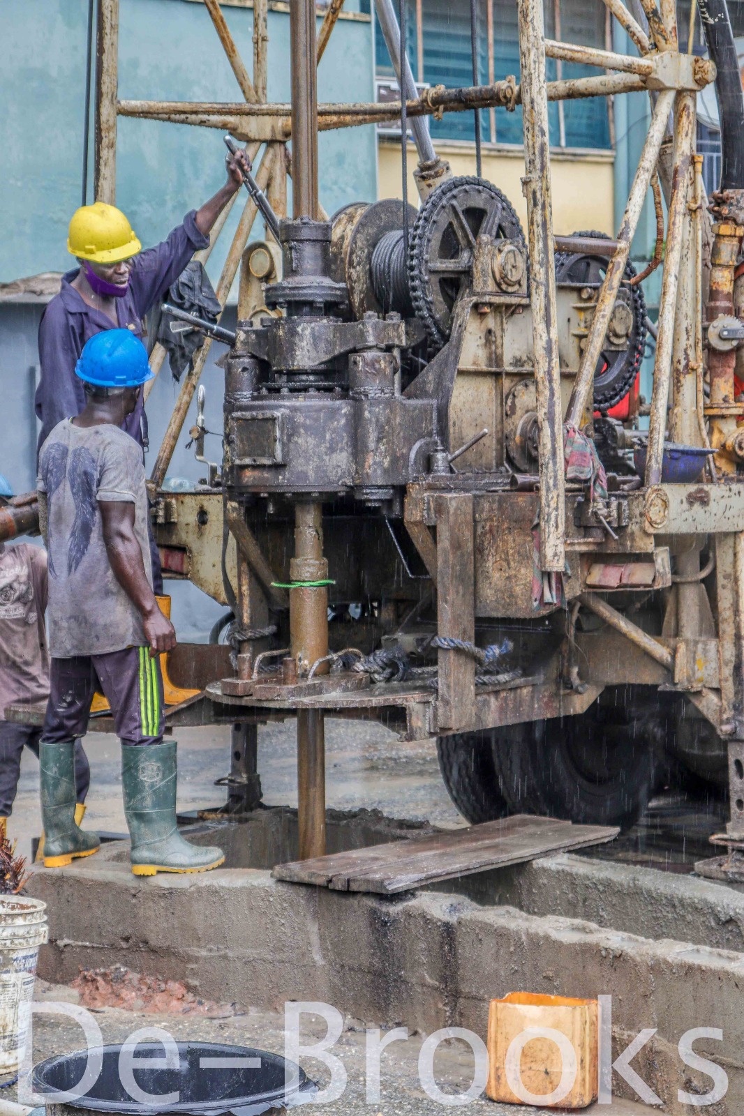 Borehole drilling rig with water discharging strongly at a completed borehole