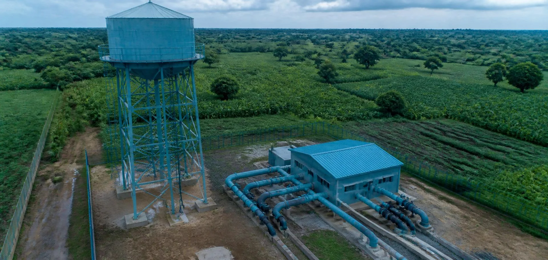 Elevated water storage tank and pump house serving farmland